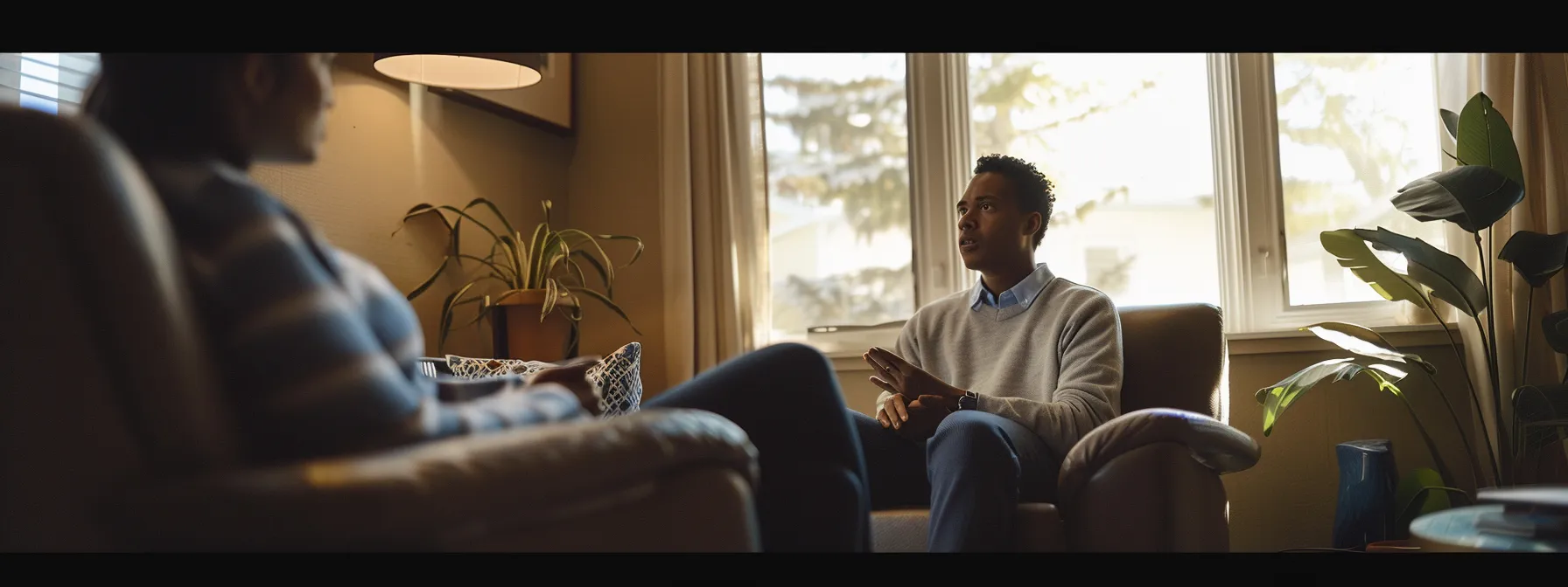 a person sits in an office, talking to a therapist, surrounded by comforting and welcoming decor.