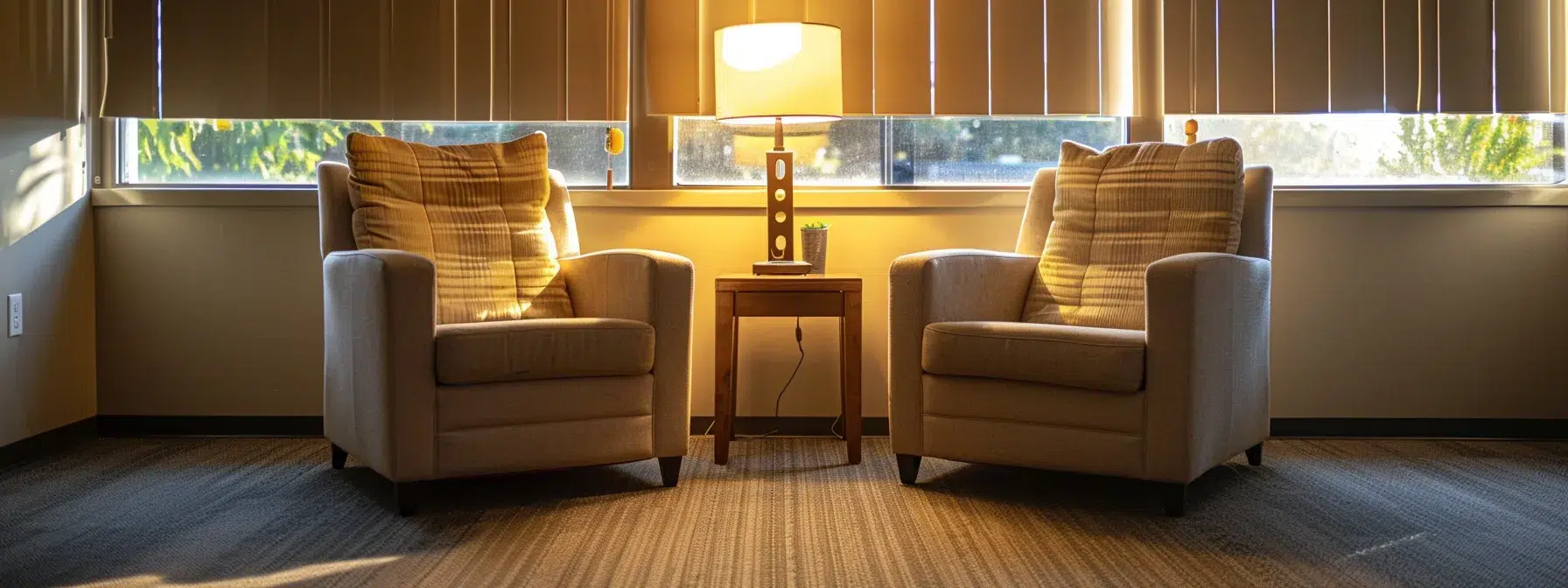 a cozy, professionally decorated counseling office features two plush armchairs positioned towards each other, with soft, ambient lighting casting a warm glow, symbolizing a safe space for couples to engage in meaningful conversations about their marriage and relationships.