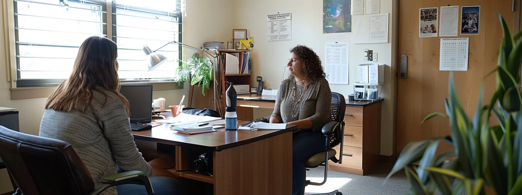 a focused individual is seated at a modern desk in a well-lit office, engaged in a thoughtful conversation with a diverse group of counselors, with various therapy-related materials and resource pamphlets visibly arranged around them, symbolizing the importance of finding the right fit in counseling.