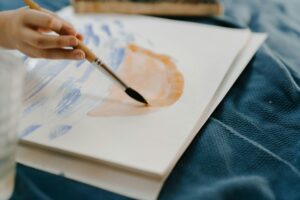 Client engaging in art therapy during a cognitive behavioral session, using creative expression to explore and manage thoughts and emotions.