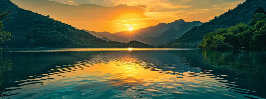a breathtaking sunset casts a warm golden hue over a serene lake, surrounded by lush green mountains reflecting beautifully in the calm water.