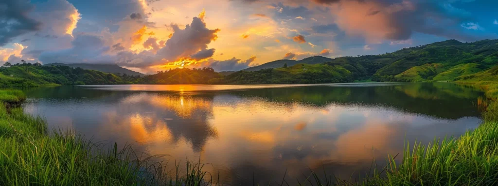 a vibrant sunset casts golden rays over a tranquil lake, reflecting the fiery colors of the sky amidst lush, green hills.