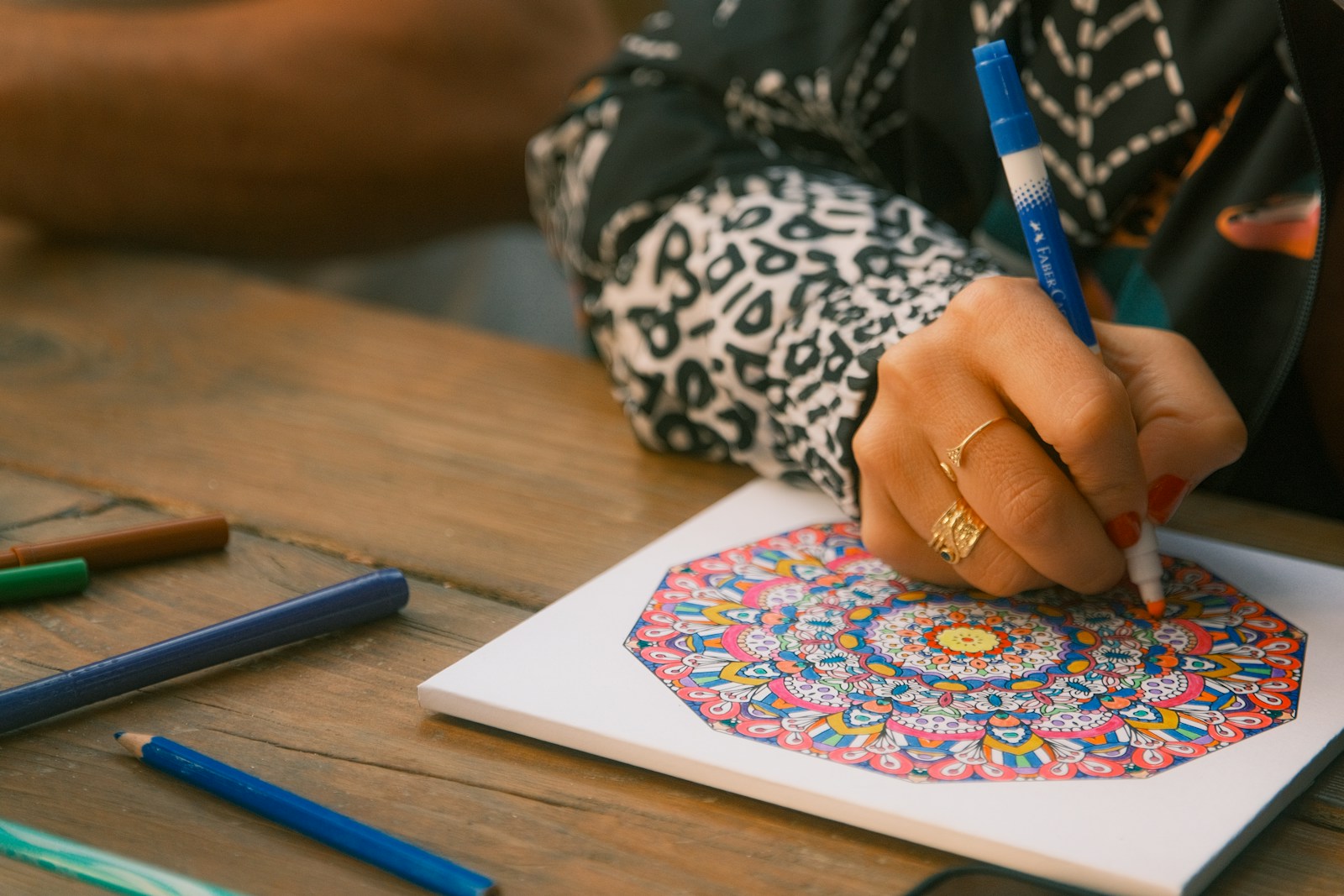 Art Therapy Activities for Anxiety: A Therapist's Guide 2 Hands coloring a detailed mandala with markers on paper