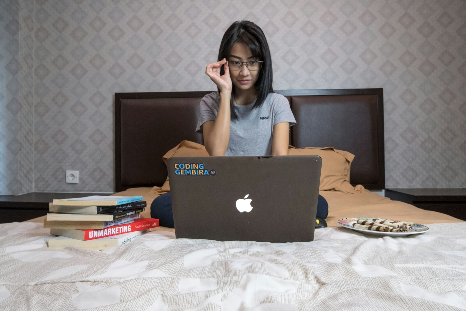 A woman in a gray shirt working focused at her laptop