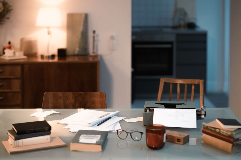 A warm and inviting home workspace featuring a typewriter, books, and ambient lighting for creative writing.
