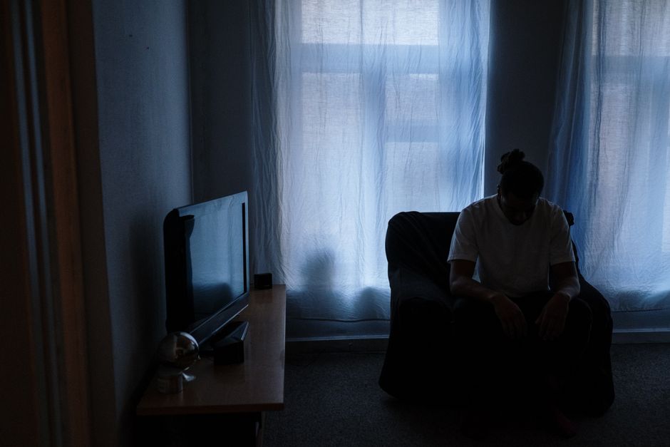 A person sits alone in a dimly lit room, reflecting solitude after a long shift.