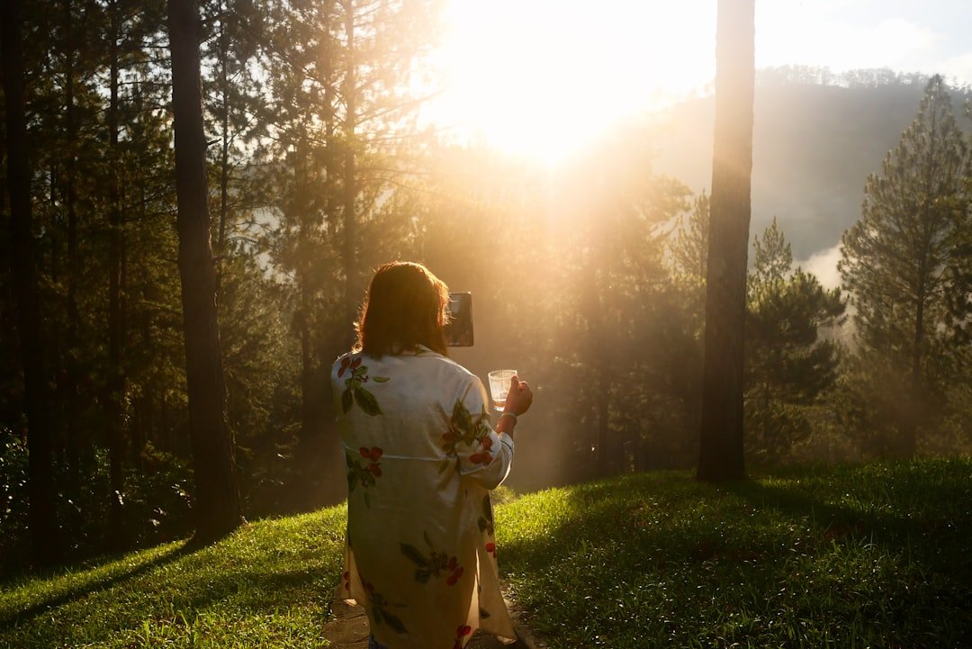 Aetna Arizona: Mental Health and Virtual IOP Coverage 8 Woman taking a picture in a sunlit forest.