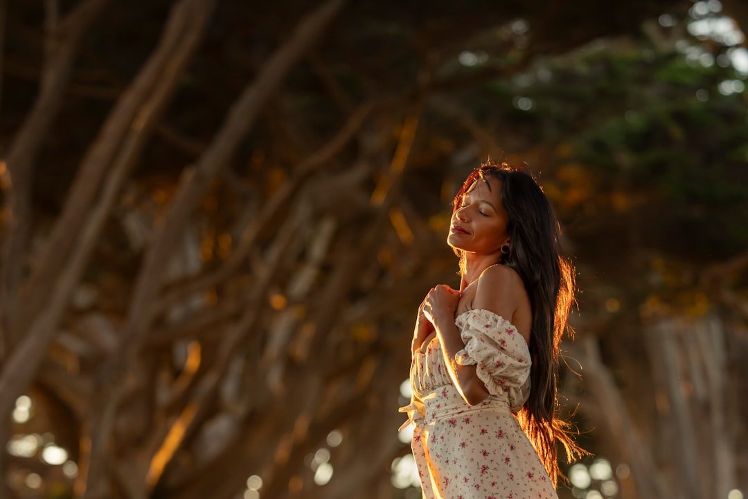 Woman with long dark hair in a floral dress.