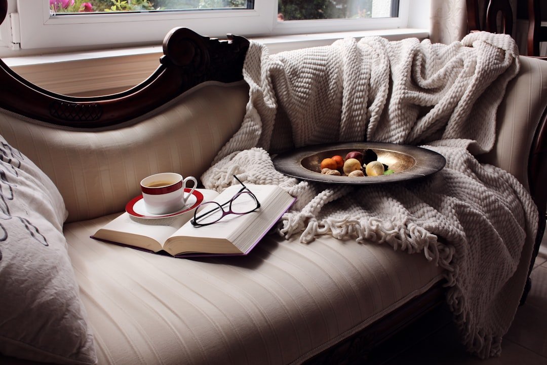 A cozy chaise lounge with a book, coffee, and snacks.