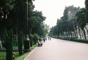People enjoy a calm walk on a very green section of the Baku Boulevard.