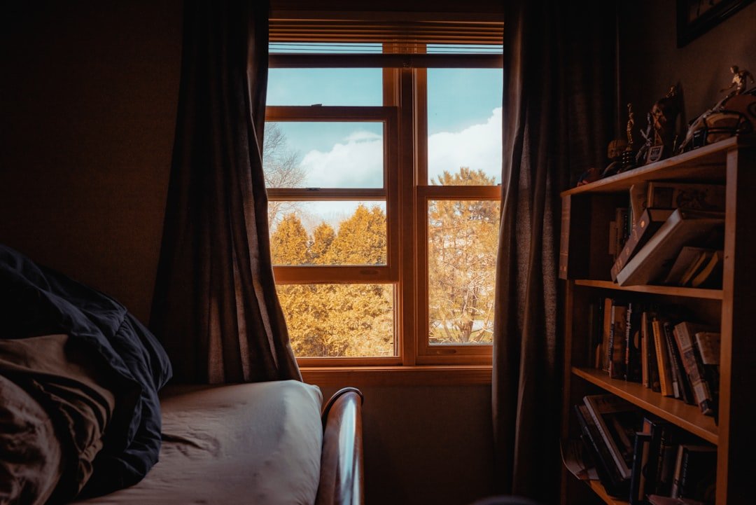 white bed near brown window curtain.