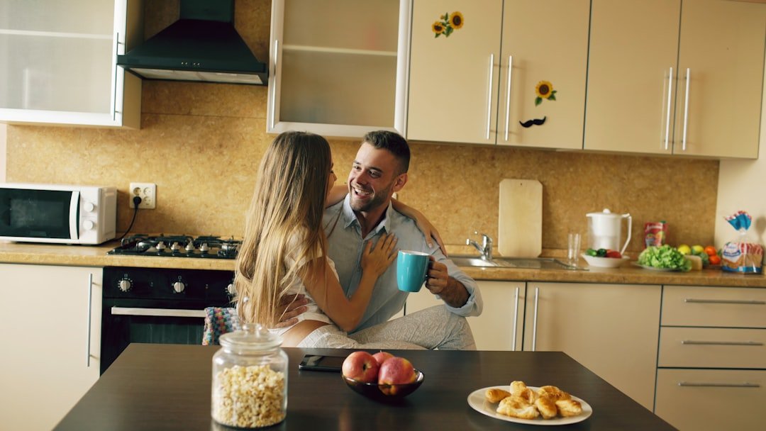 Attractive young couple embracing early morning in the kitchen.