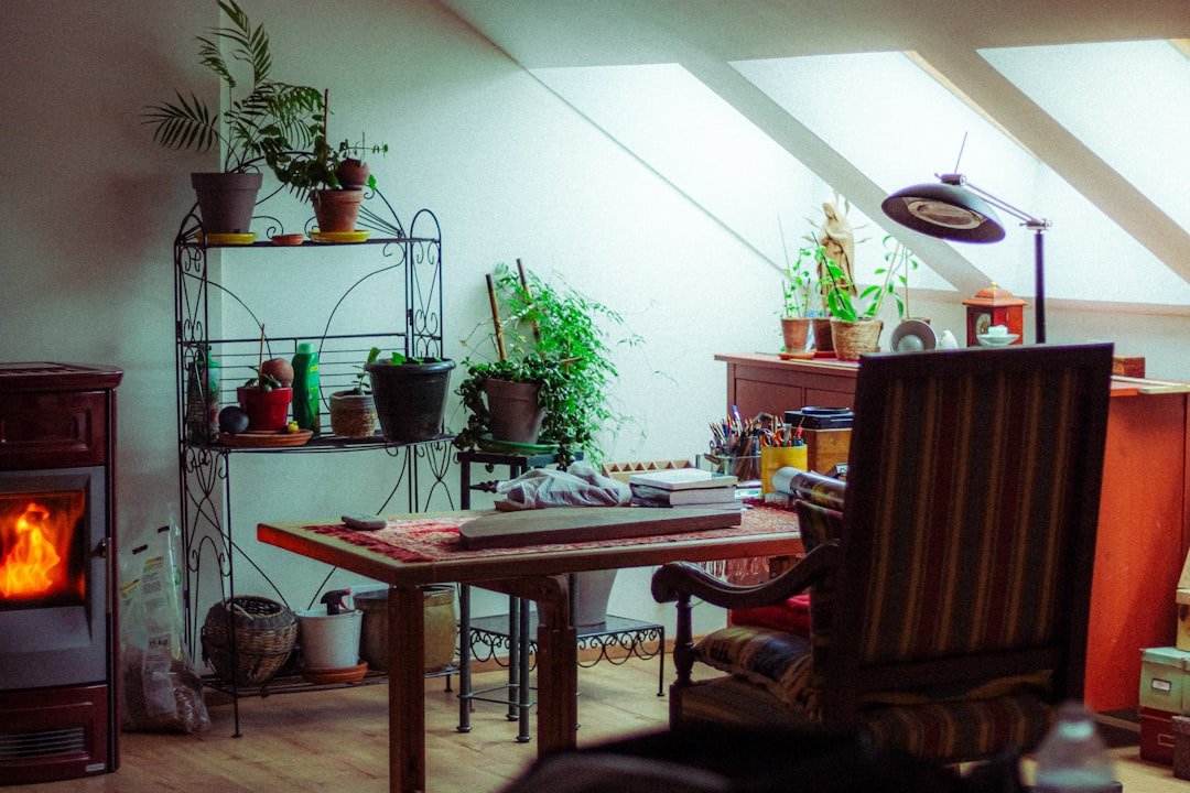 Cozy room with desk, plants, and fireplace.