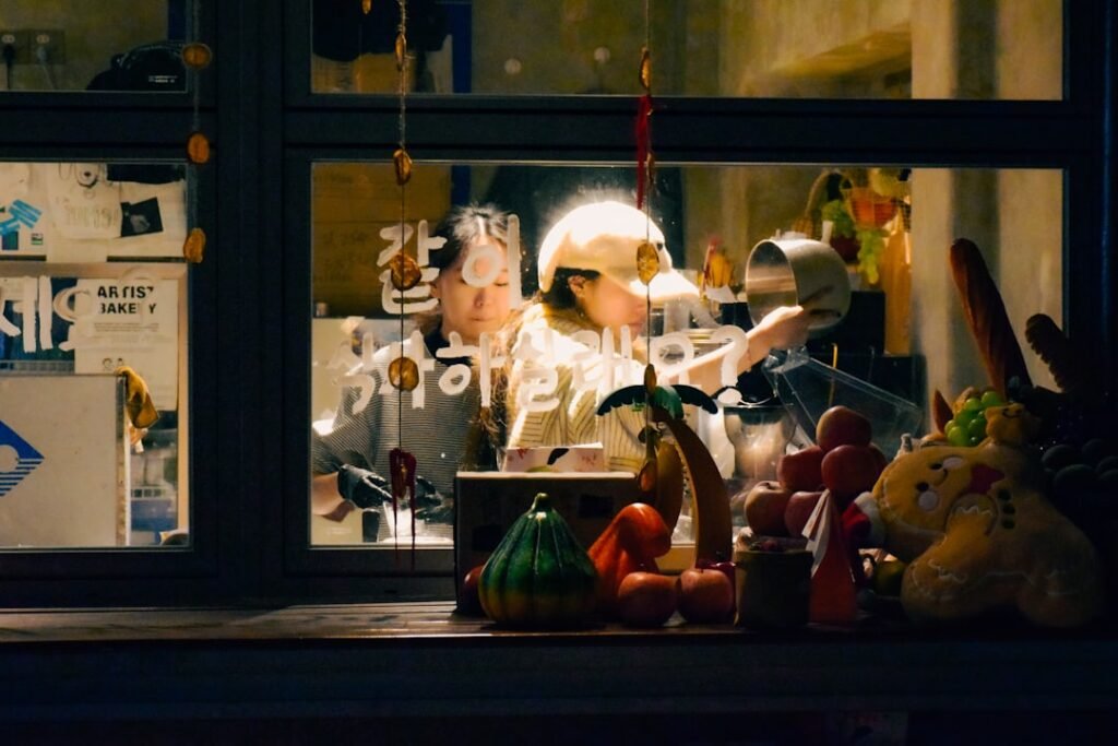 Two people working behind a counter at night.