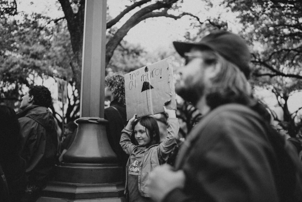 A young girl holds a sign in a crowd.