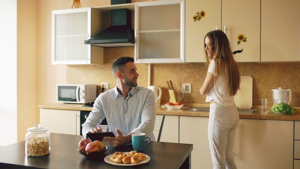UnitedHealthcare (and Optum behavioral health): Mental Health and Virtual IOP Coverage 1 Happy young man using digital tablet computer sitting in the kitchen and talking his wife while she cooking at home in the morning.