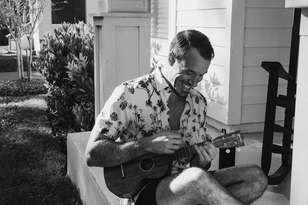 UnitedHealthcare (and Optum behavioral health): Mental Health and Virtual IOP Coverage 8 Man playing a Martin ukulele in black and white on a front porch. Alex Sanfilippo, Founder of PodMatch.com.