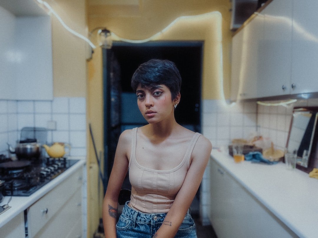 a woman standing in a kitchen next to a stove top oven.