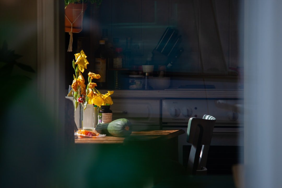 yellow flower on brown wooden table.