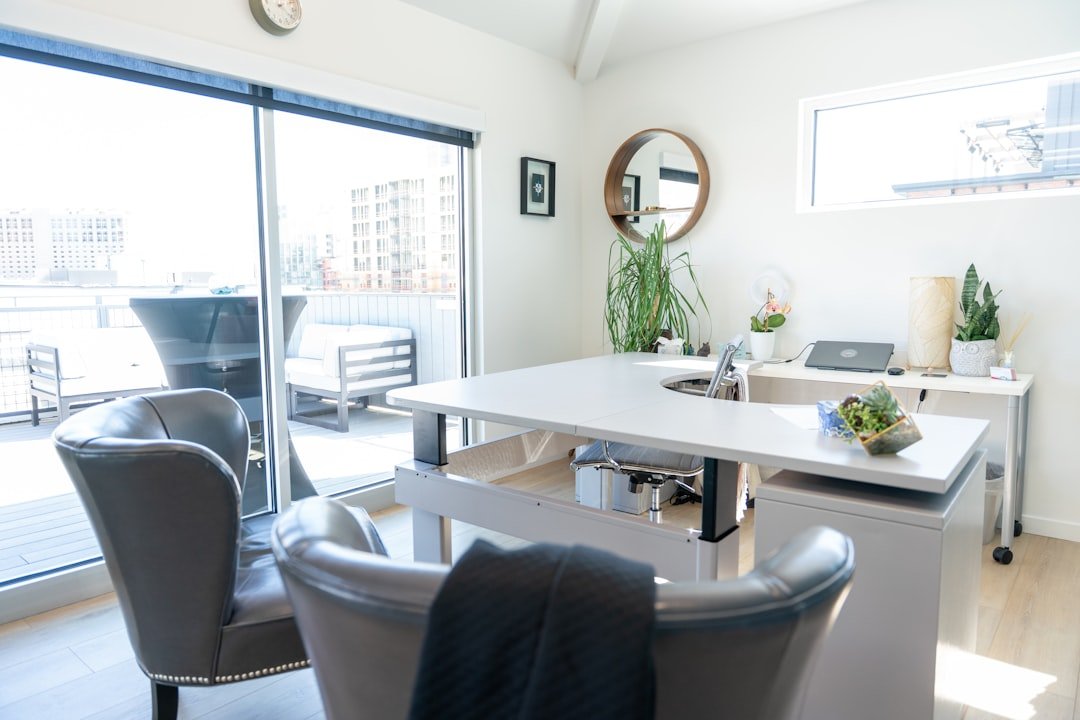 This executive office at Deliberate Directions features a wraparound desk, soft natural light, and access to a private rooftop patio. With greenery, modern furnishings, and personal touches like a succulent arrangement and mirror accent, the space blends professionalism with comfort. It’s designed for focused work, meaningful conversations, and leadership coaching with a view.