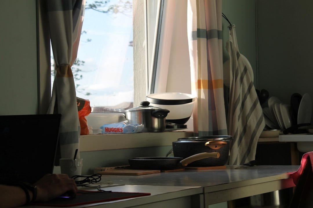 Kitchen counter with window and cooking supplies.