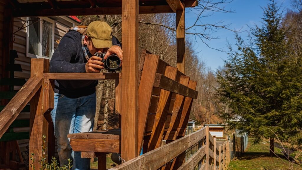 Virtual IOP in Gilbert, Arizona 1 Man taking a photo with the Black Magic Pocket Cinema Camera 6K in the mountains of Trade, TN on an Airbnb porch of a tiny house on a farm.
