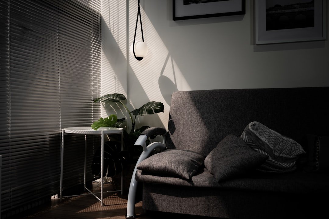 gray sofa chair beside window.