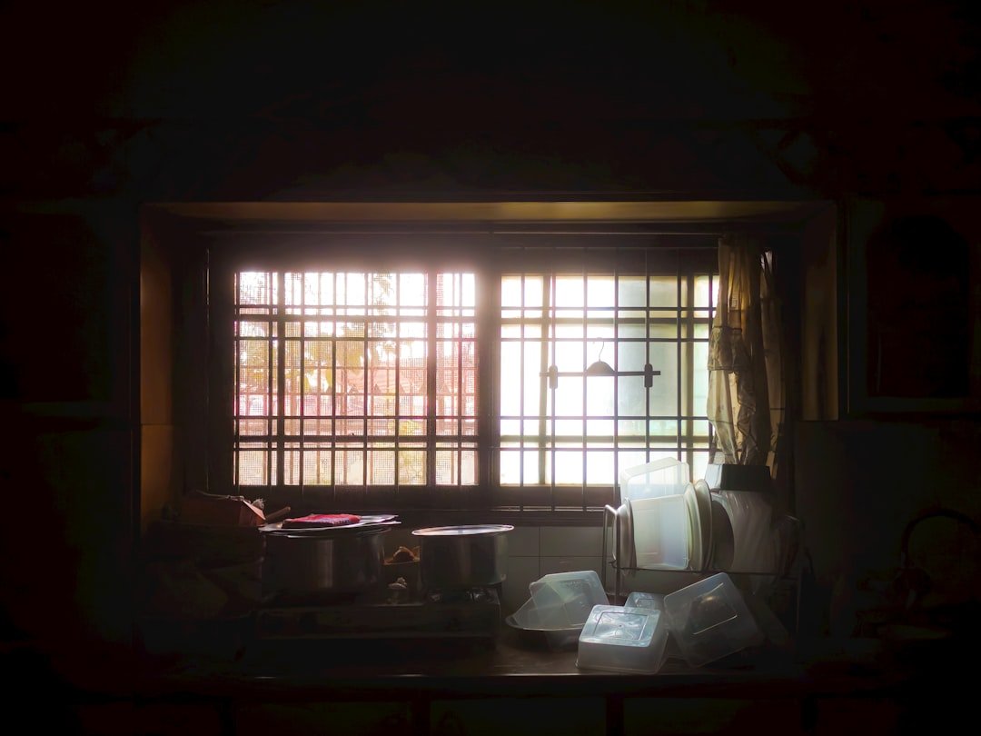 Sunlight streams through a window with blinds.
