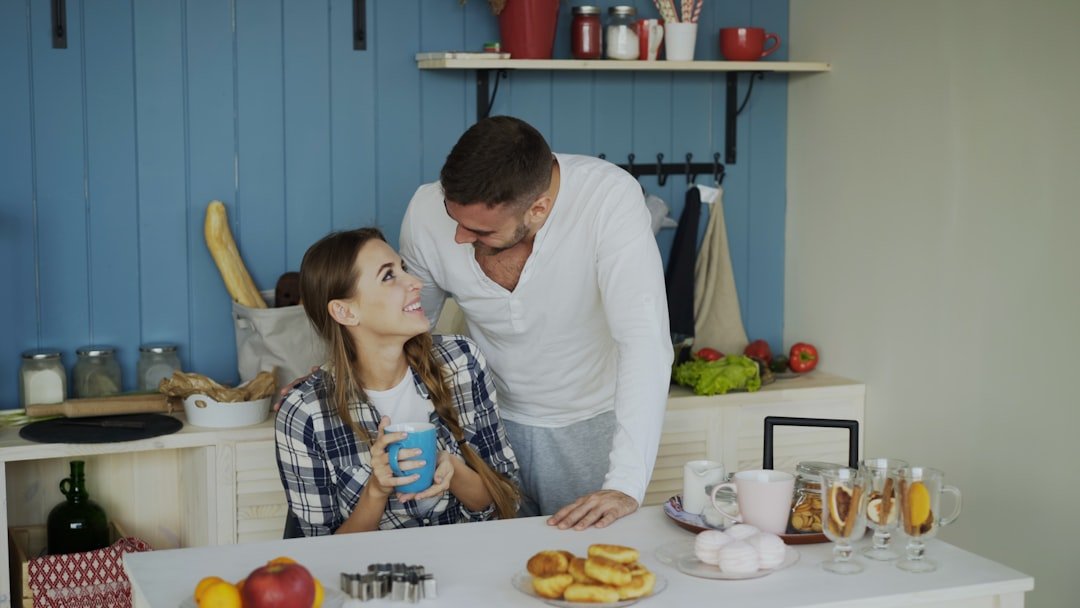 Virtual IOP in San Diego, California 8 Attractive couple meet and kiss in the kitchen at breakfast time at home in the morning.