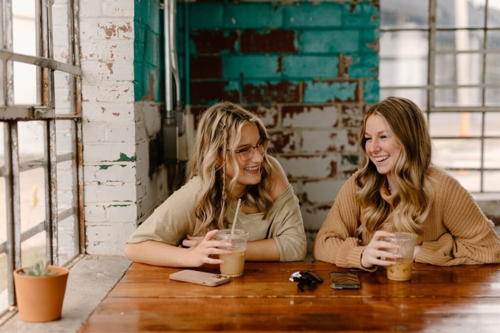 two women sitting at a table with drinks.