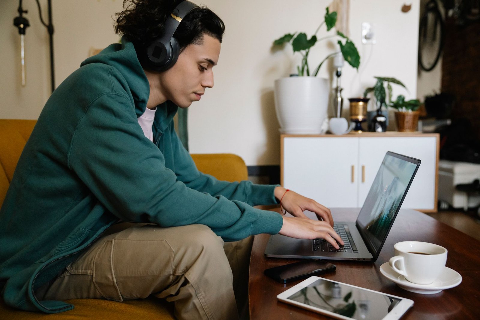 Anthem vs UnitedHealthcare for Mental Health in Indiana (2026) 6 Side view of ethnic male distance employee in headset working on netbook at table with laptop and coffee in room