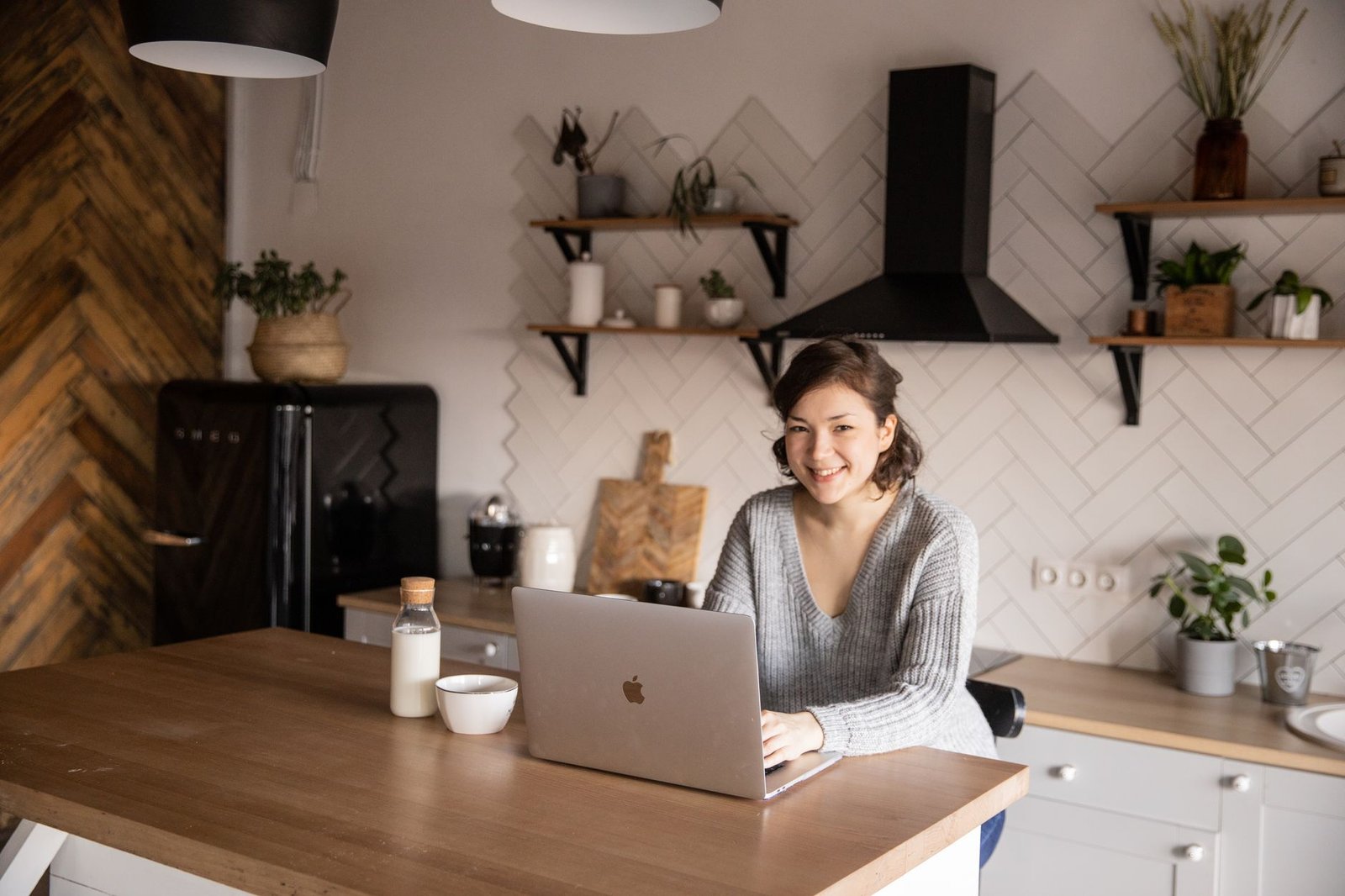 Open Enrollment 2027 in Indiana: Picking a Plan for Mental Health 7 Cheerful female in casual clothes sitting at table with laptop and bottle of milk while browsing internet on laptop during free time at home and smiling looking at camera