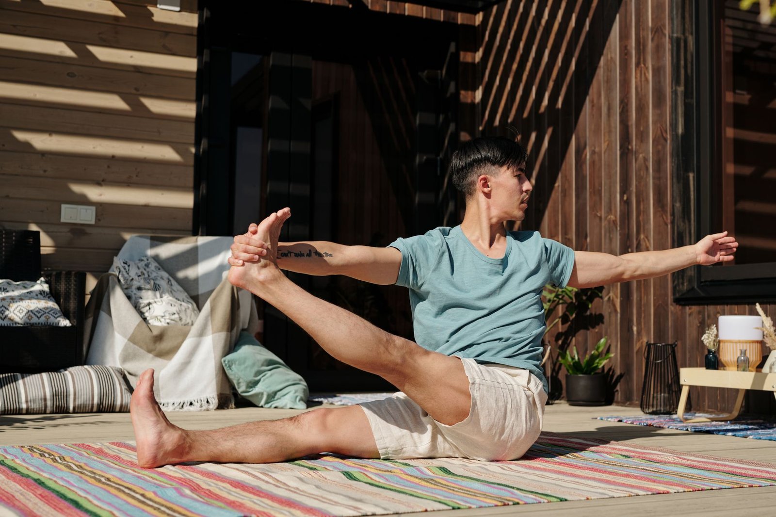 16 Emotion Regulation Activities for Adults, From a Clinical Team 8 Young man performing yoga stretches outdoors on a colorful mat during daytime.