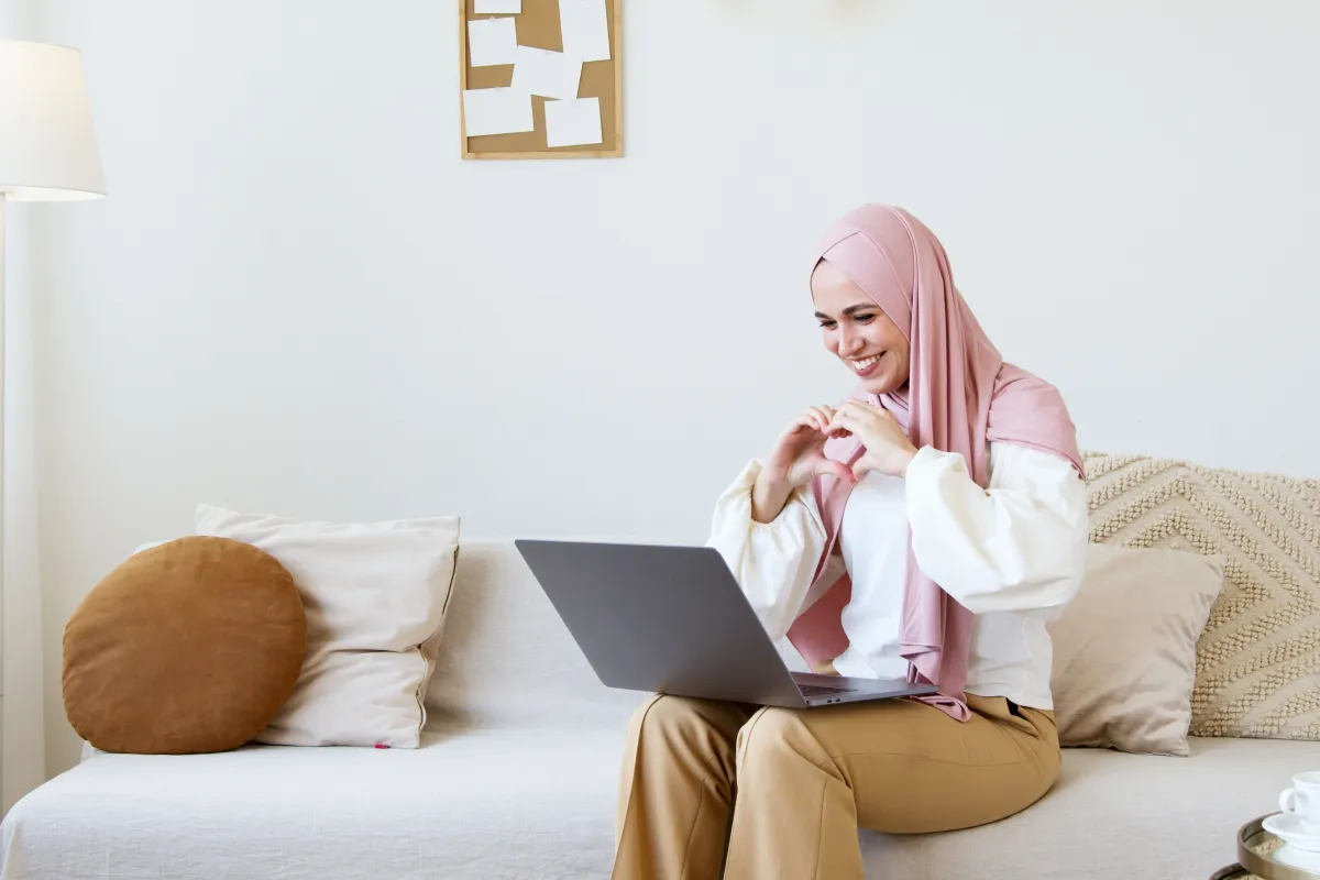 A woman smiling on a video call from her sofa at home