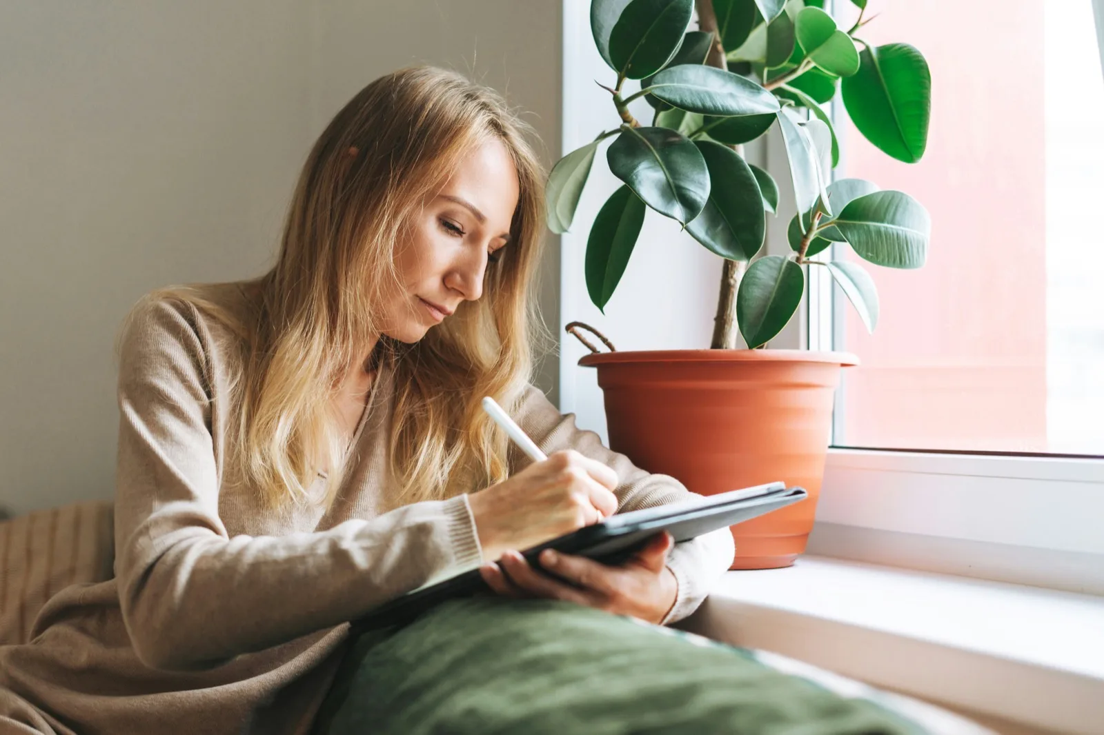 Young adult writing in her notebook at home