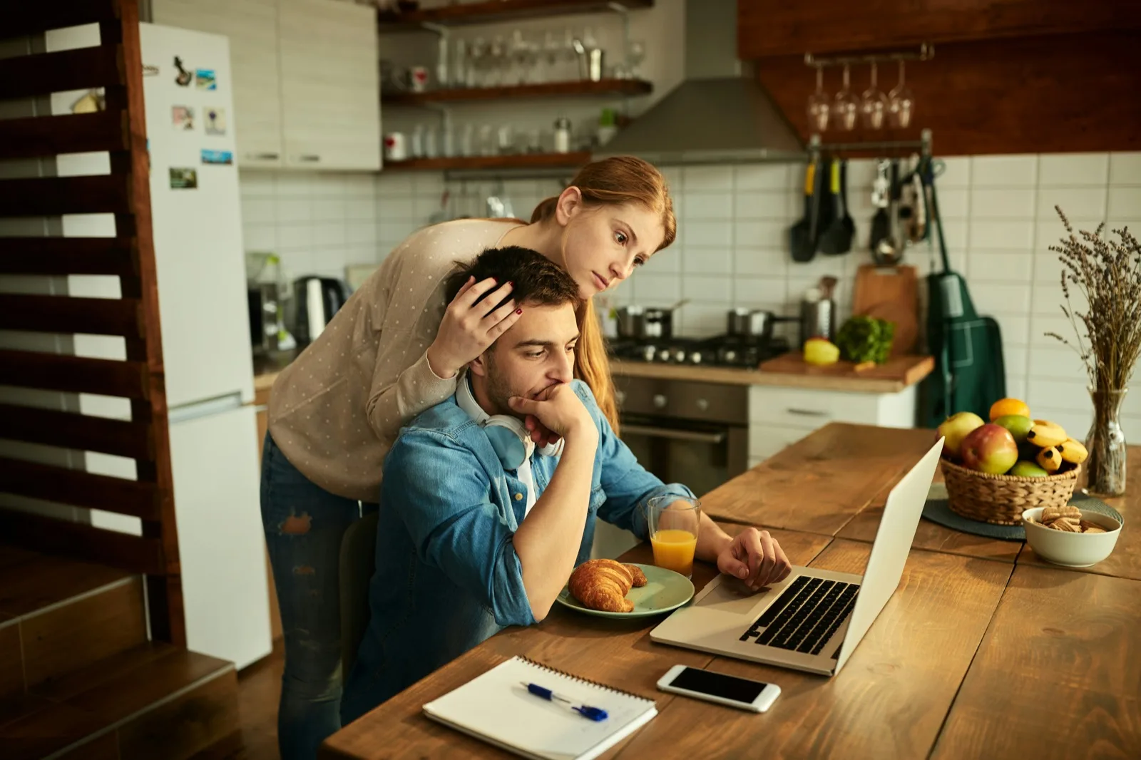 Young adult hugging a family member at the kitchen table