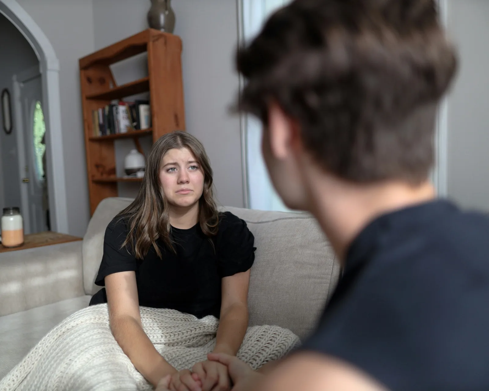 Young adult listening closely to a friend on the couch