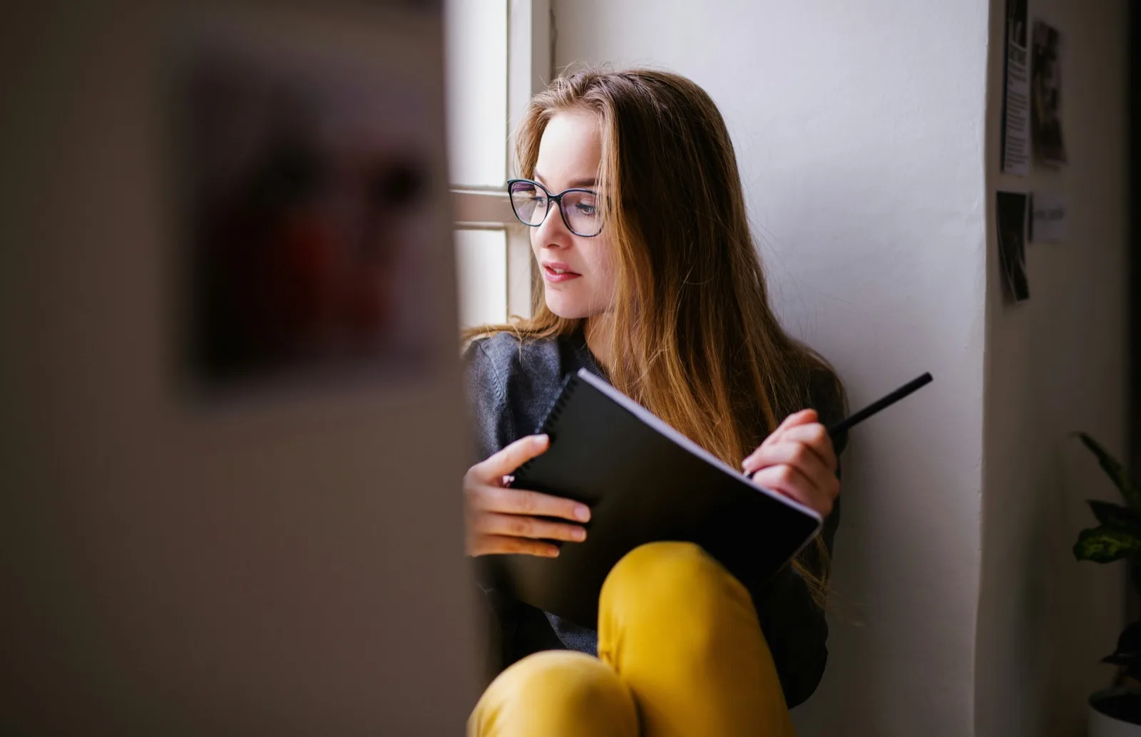 Young adult reading her notes by the window