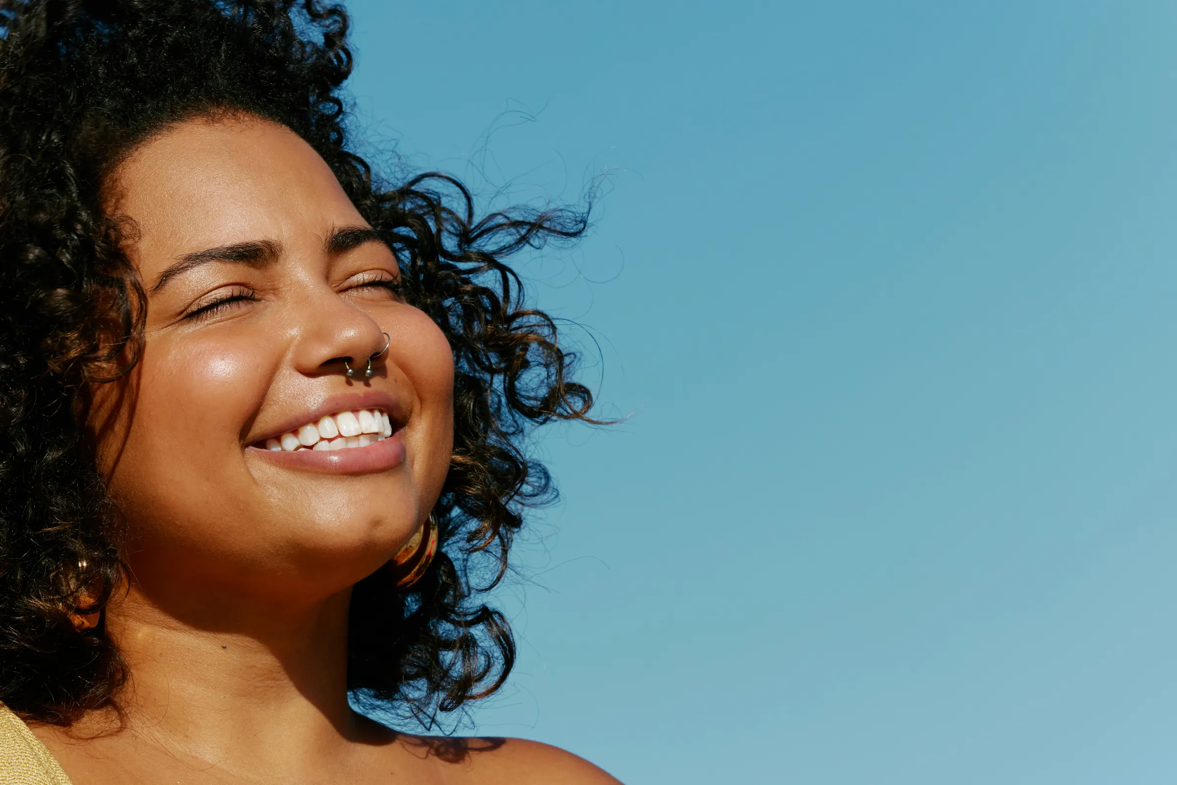 Woman laughing with her eyes closed in the sun