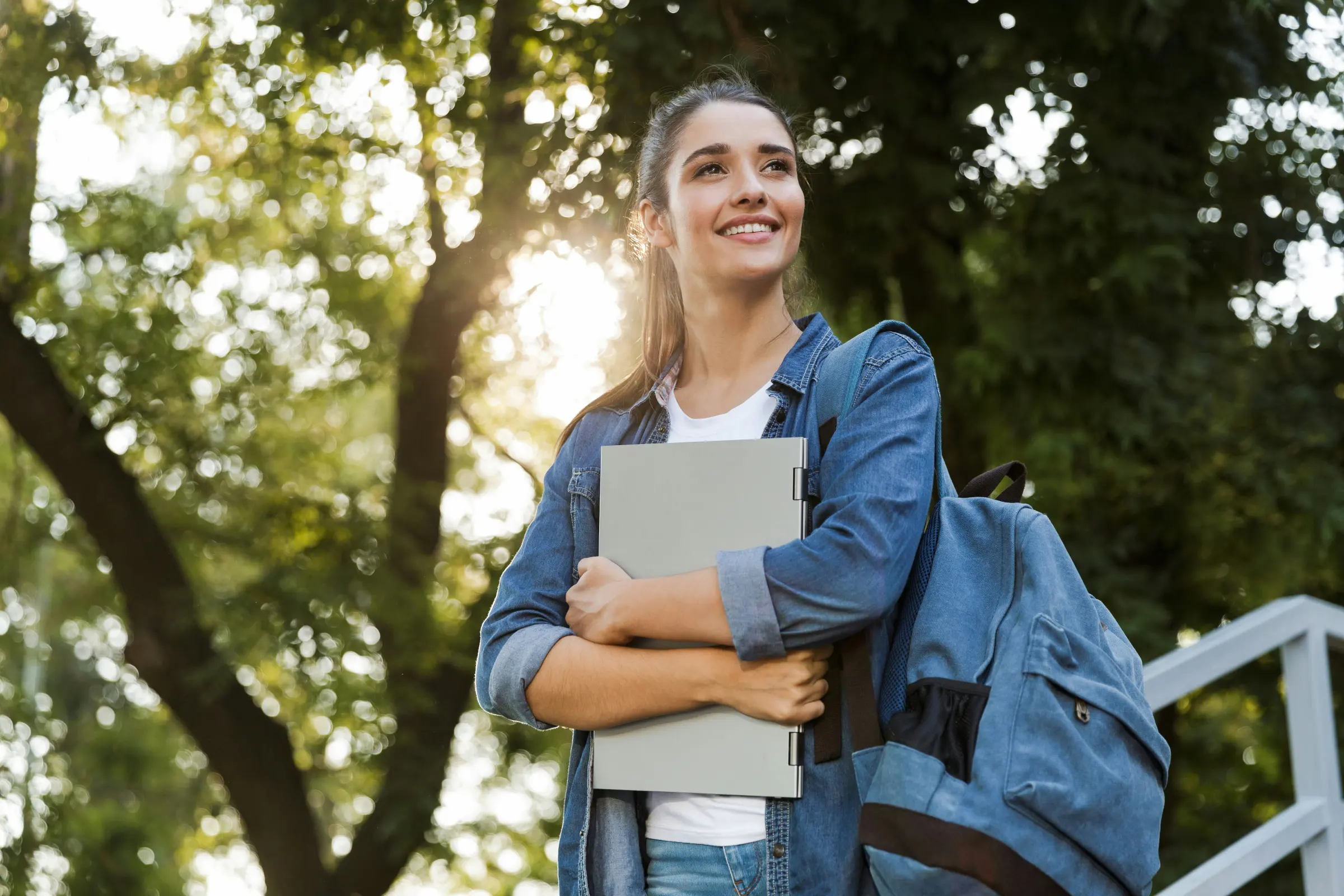 College student with a backpack smiling outdoors