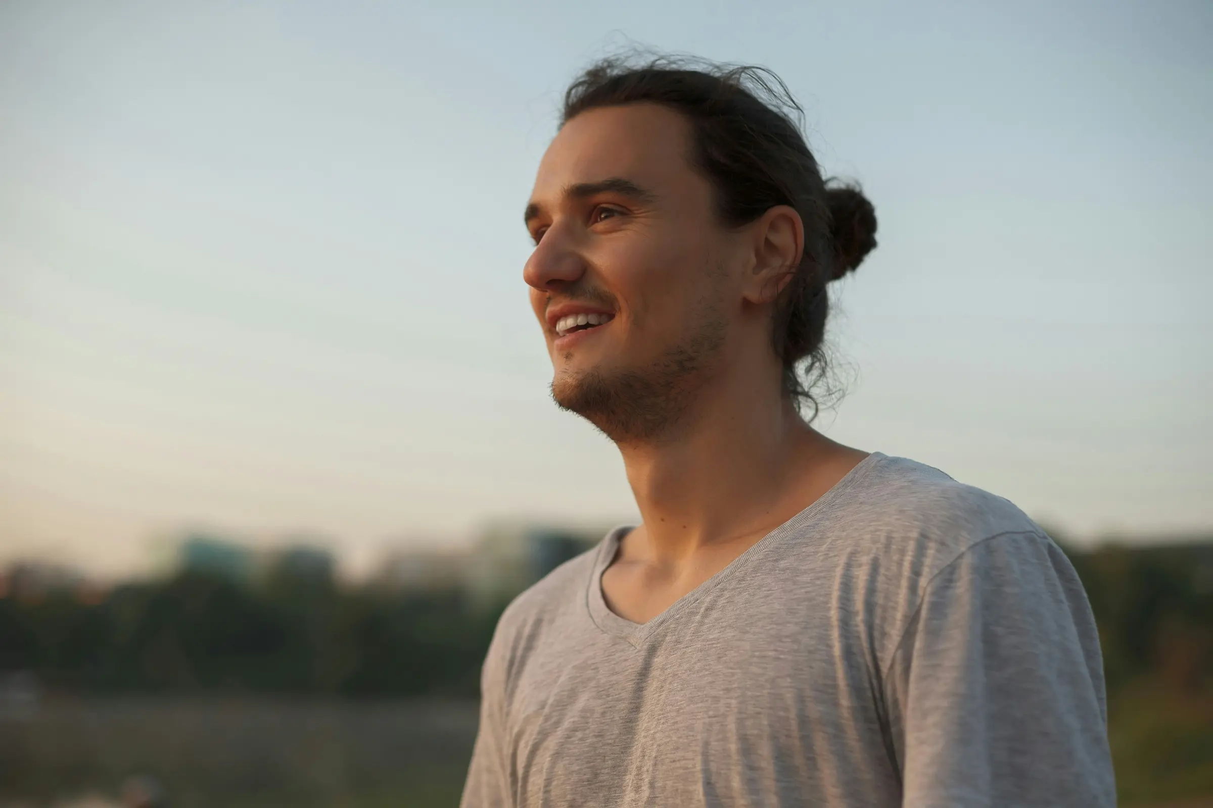Man smiling outdoors at sunset